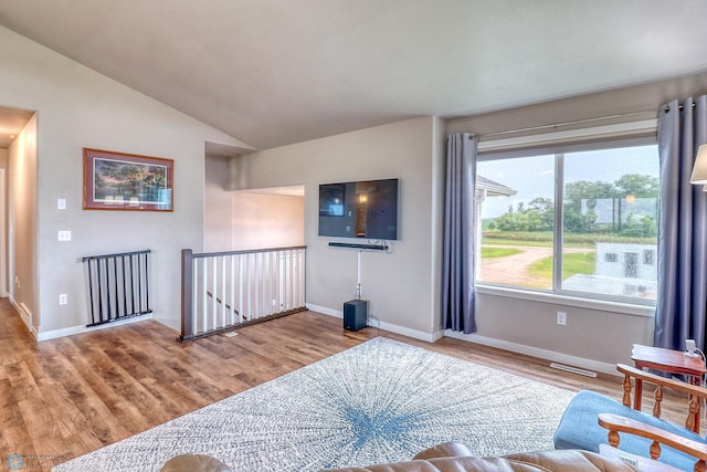 living room with vaulted ceiling and light hardwood / wood-style flooring