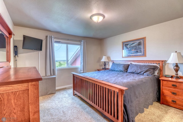 bedroom featuring light carpet and a textured ceiling