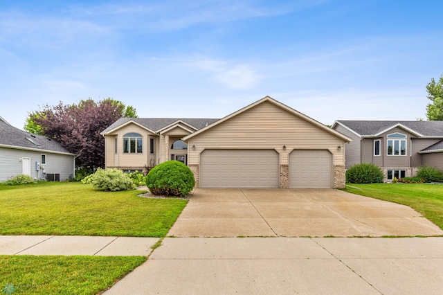 view of front of house featuring central air condition unit, a garage, and a front lawn