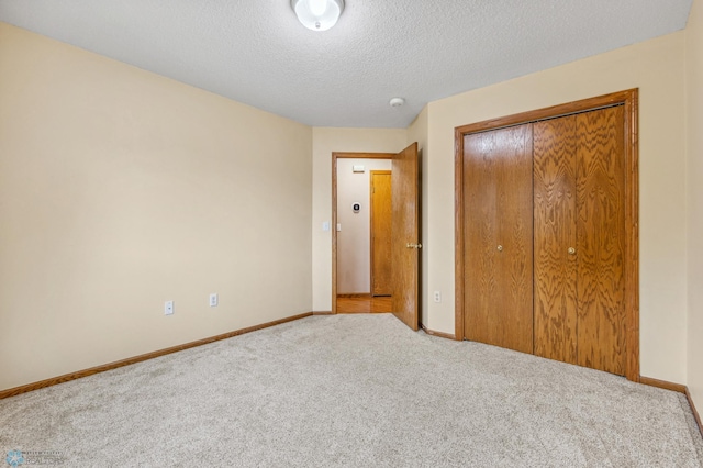 unfurnished bedroom featuring carpet, a closet, and a textured ceiling