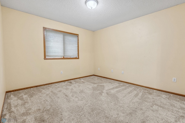 carpeted empty room with a textured ceiling