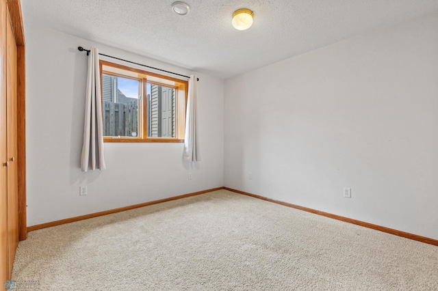 spare room with a textured ceiling and carpet flooring