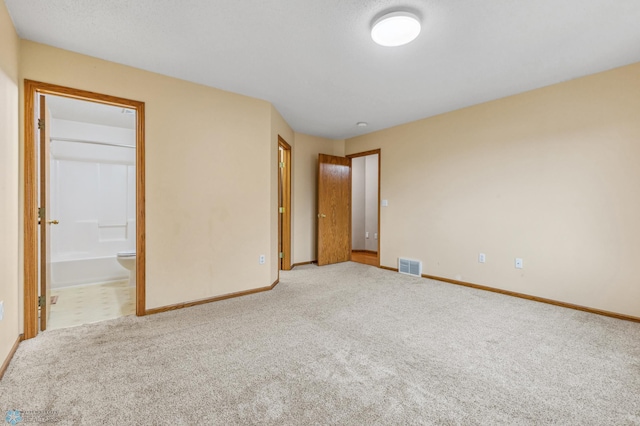 unfurnished bedroom featuring carpet floors and connected bathroom