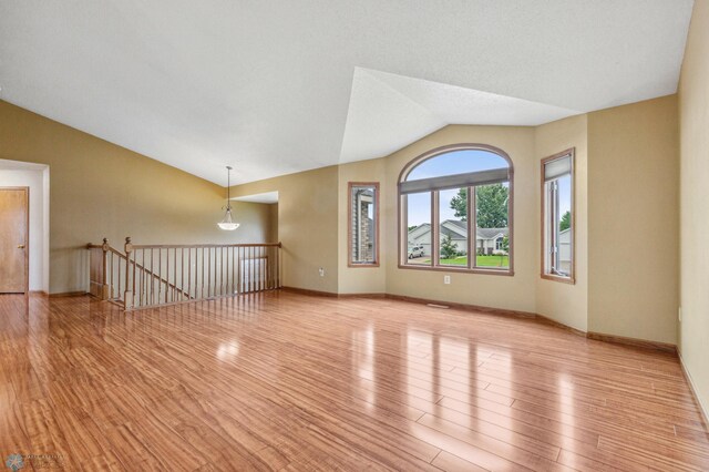 unfurnished living room featuring light hardwood / wood-style floors and lofted ceiling