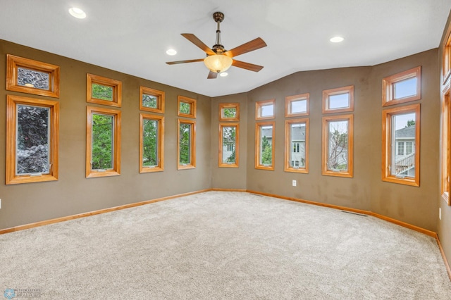 carpeted spare room featuring ceiling fan and vaulted ceiling