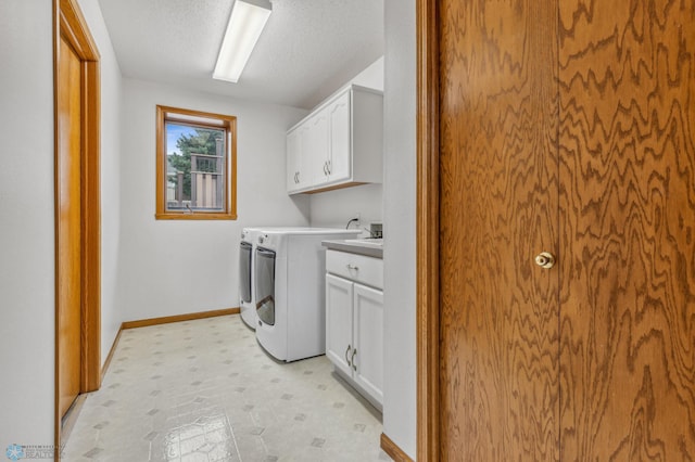 washroom featuring a textured ceiling, cabinets, separate washer and dryer, and light tile patterned floors