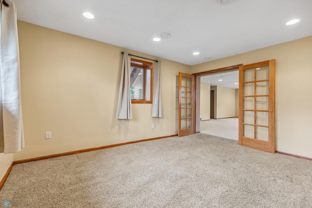 carpeted spare room featuring french doors