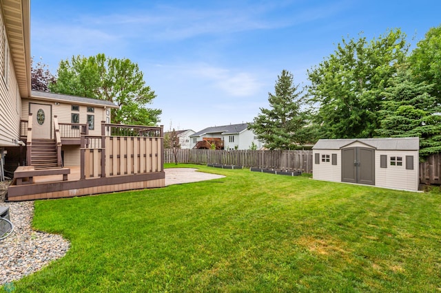 view of yard with a wooden deck and a storage unit