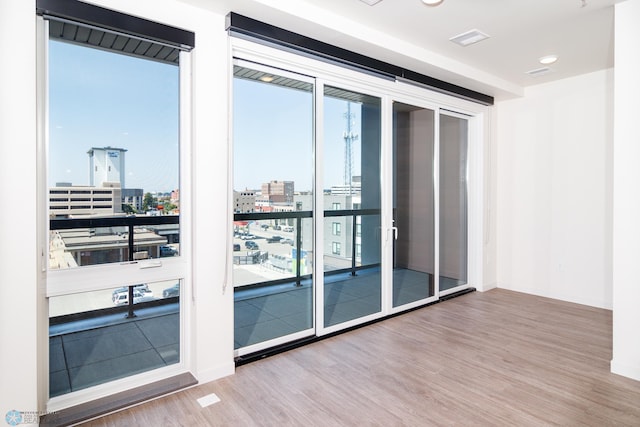 empty room with expansive windows and hardwood / wood-style flooring