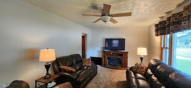 living room featuring a textured ceiling, carpet flooring, and ceiling fan