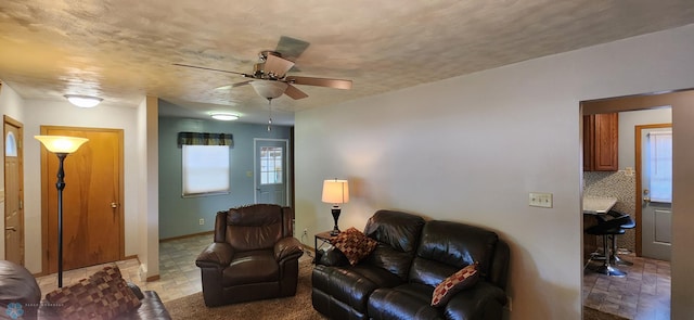 tiled living room featuring ceiling fan and a healthy amount of sunlight