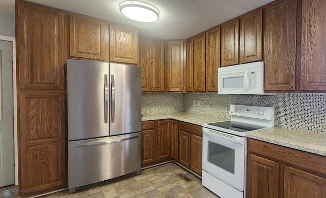 kitchen featuring tasteful backsplash, white appliances, and light tile patterned floors