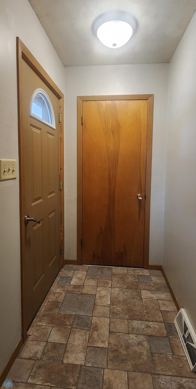 doorway to outside with dark tile patterned flooring