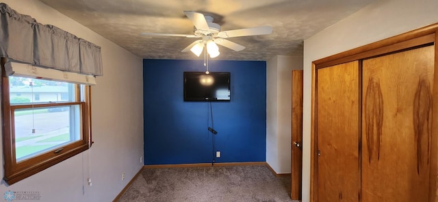 unfurnished bedroom with ceiling fan, carpet flooring, and a closet