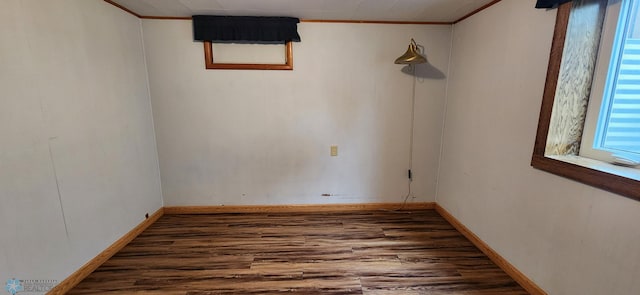 empty room with ornamental molding and hardwood / wood-style floors