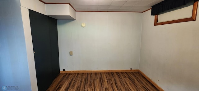 unfurnished room with dark hardwood / wood-style floors and a paneled ceiling