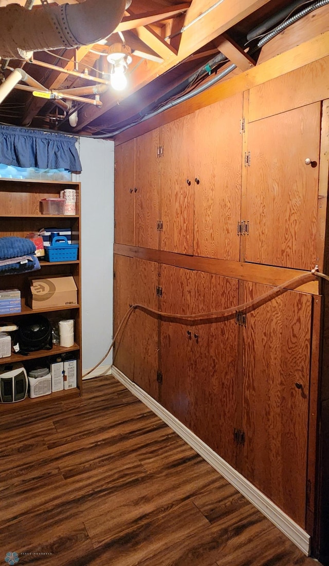 basement with hardwood / wood-style floors and wooden walls