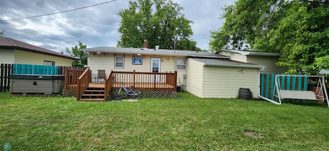 rear view of house with a deck and a yard