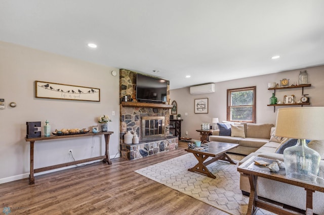 living room featuring a wall mounted AC, a fireplace, and hardwood / wood-style floors