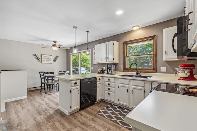 kitchen with black appliances, white cabinets, light hardwood / wood-style floors, and kitchen peninsula