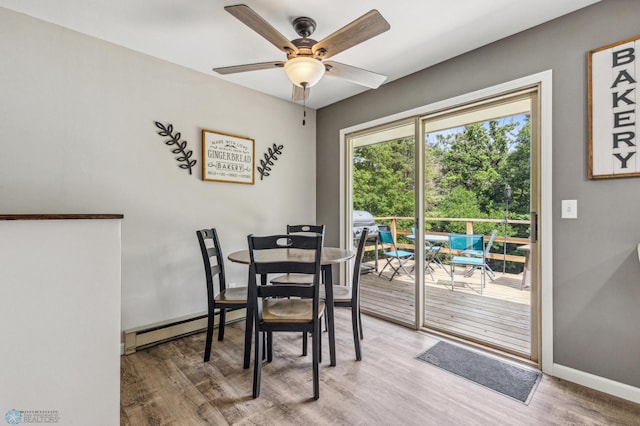 dining space with a baseboard heating unit, ceiling fan, and hardwood / wood-style flooring