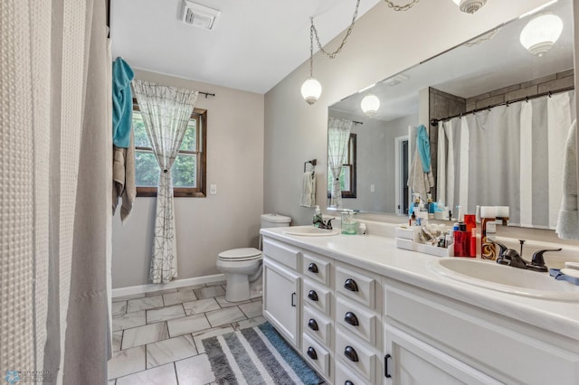 bathroom featuring toilet, tile patterned floors, and dual bowl vanity