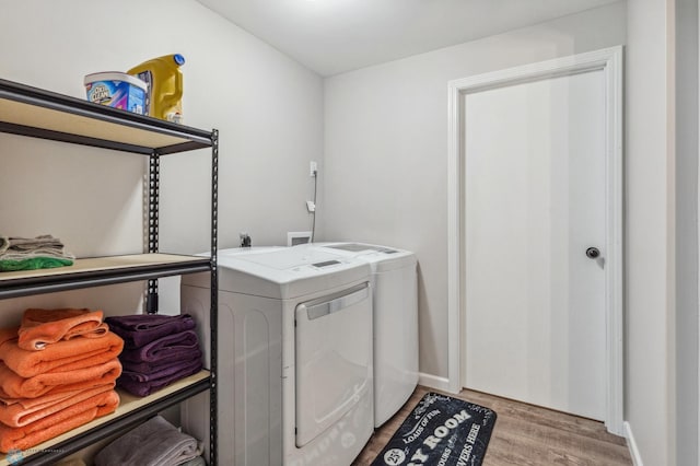 laundry area with washer and dryer and light wood-type flooring