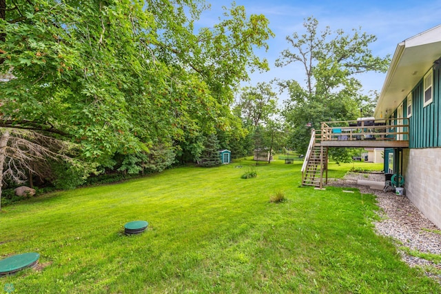 view of yard with a wooden deck and a storage shed