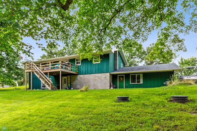 rear view of property featuring a yard and a deck