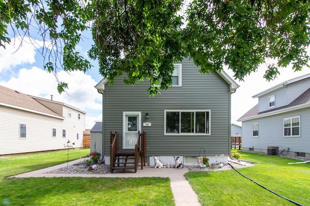 back of house featuring central AC unit and a yard