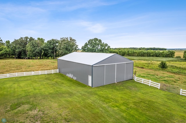 view of outbuilding with a lawn and a rural view