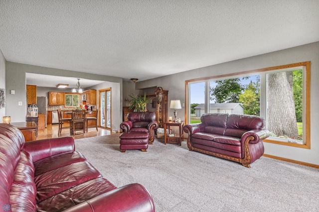 living room with a chandelier, light carpet, and a textured ceiling