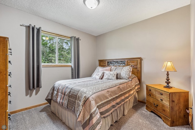 bedroom featuring a textured ceiling and light colored carpet