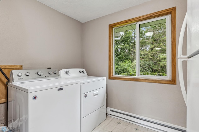 clothes washing area with a textured ceiling, a baseboard radiator, and washing machine and clothes dryer