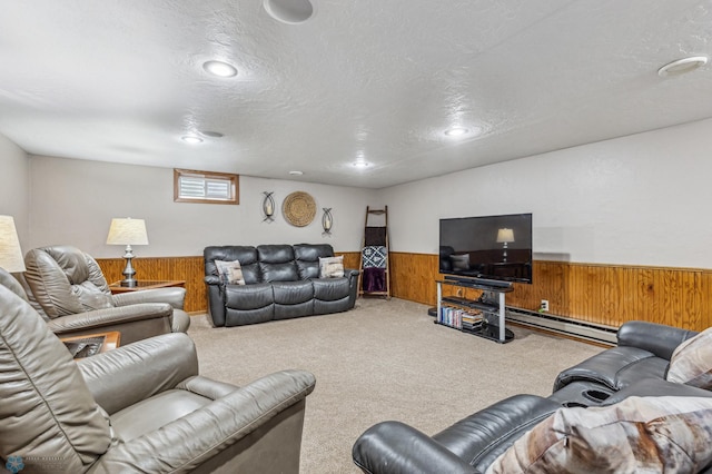 living room with wood walls, carpet, a baseboard heating unit, and a textured ceiling