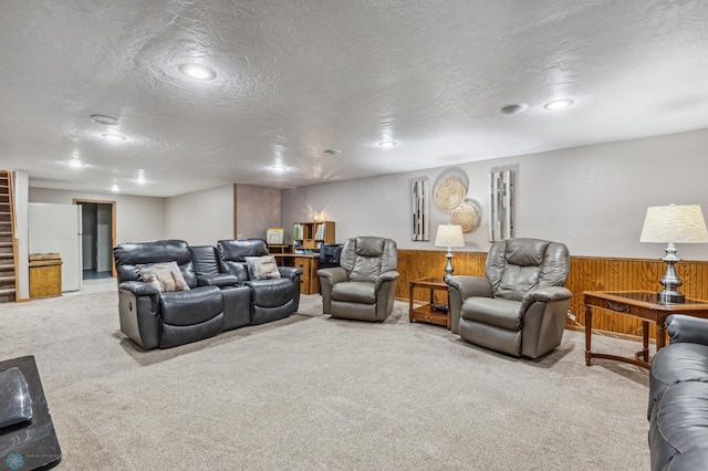 carpeted living room featuring wood walls and a textured ceiling