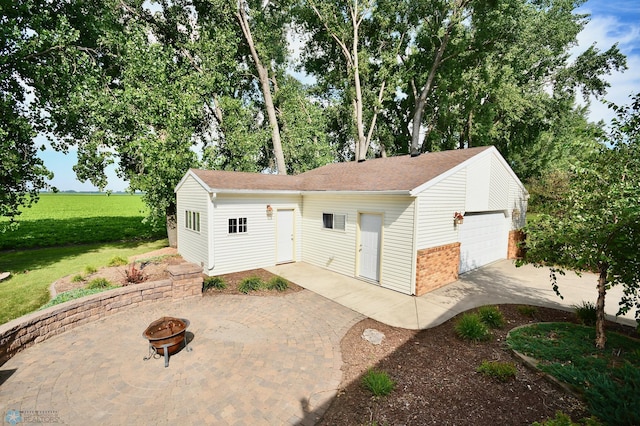 view of front of property with an outdoor fire pit, a front yard, and a patio