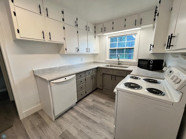 kitchen featuring light wood-type flooring, sink, white appliances, and white cabinetry