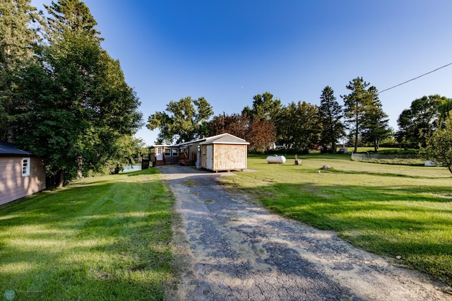 view of front of home with a front yard and a storage shed