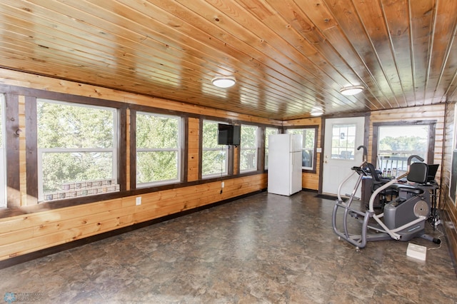 exercise area with dark tile patterned floors, wooden walls, and wooden ceiling