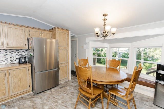 dining area with lofted ceiling, ornamental molding, a notable chandelier, and light tile patterned floors