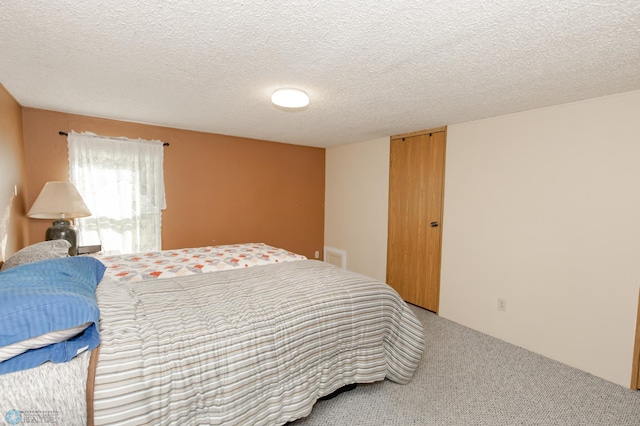 bedroom featuring a textured ceiling and carpet flooring