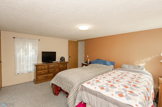 bedroom featuring carpet flooring and a textured ceiling