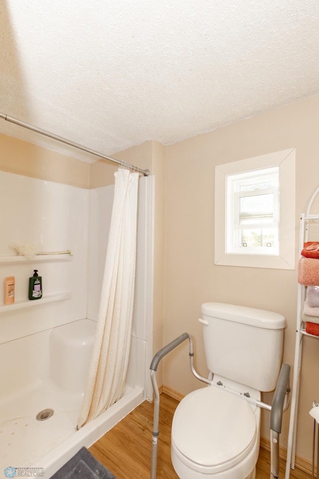 bathroom featuring curtained shower, wood-type flooring, a textured ceiling, and toilet