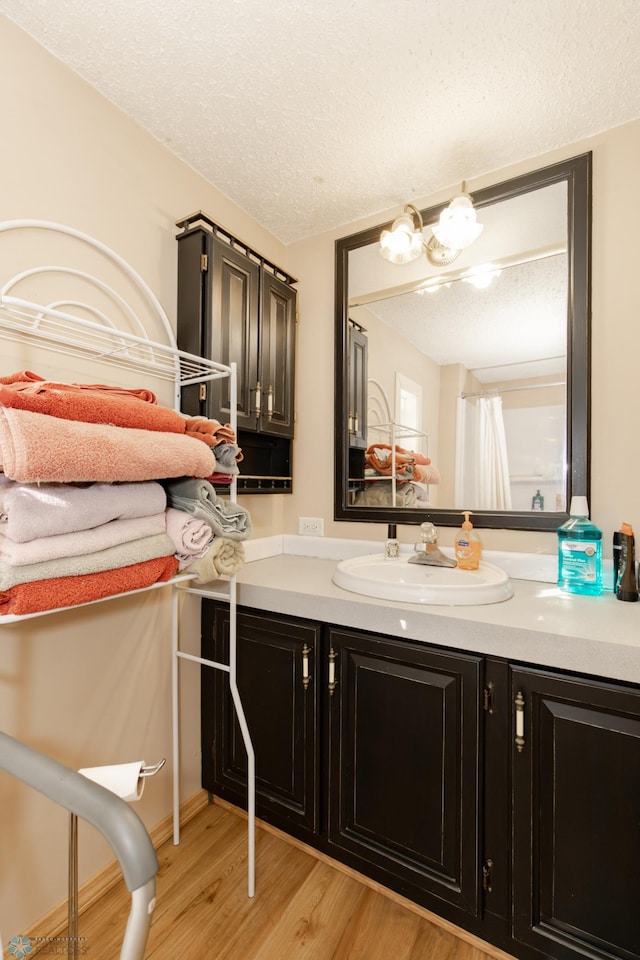 bathroom featuring vanity, a textured ceiling, and hardwood / wood-style floors