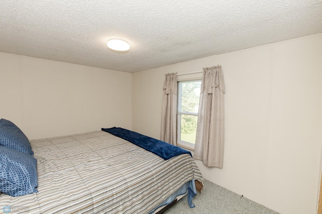 bedroom featuring a textured ceiling and light carpet