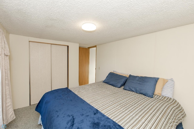 bedroom featuring carpet flooring, a textured ceiling, and a closet