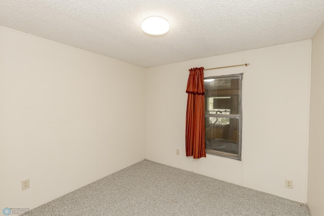 spare room with a textured ceiling and carpet floors