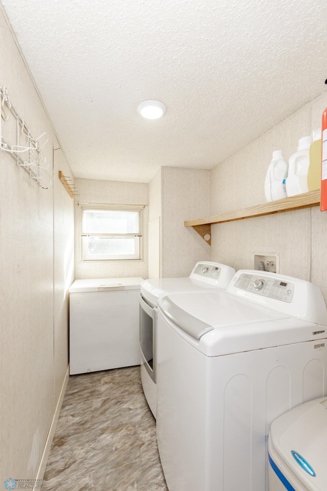 laundry area with washer and dryer and a textured ceiling