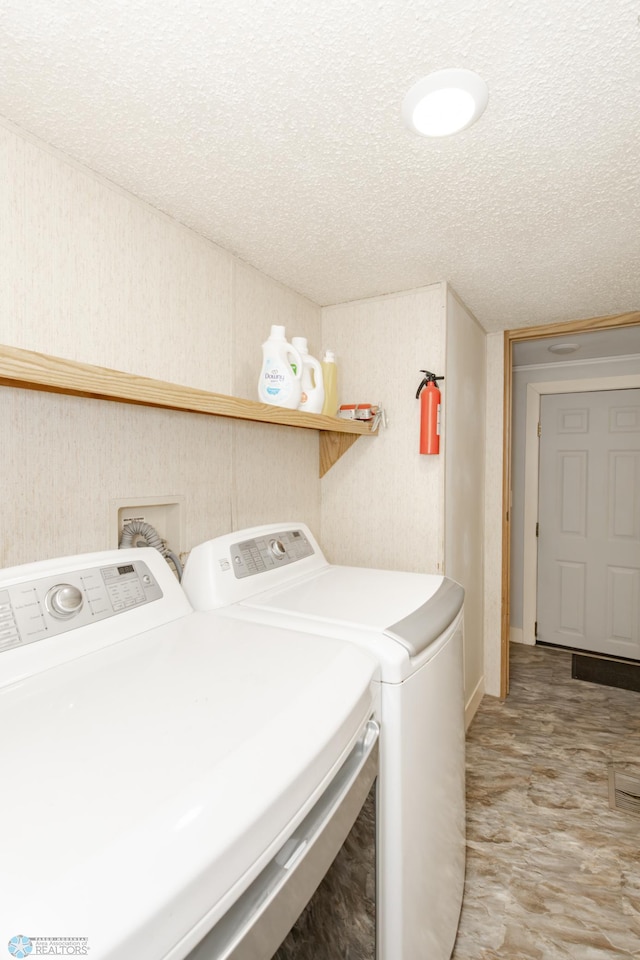 laundry area featuring independent washer and dryer, light tile patterned floors, and a textured ceiling